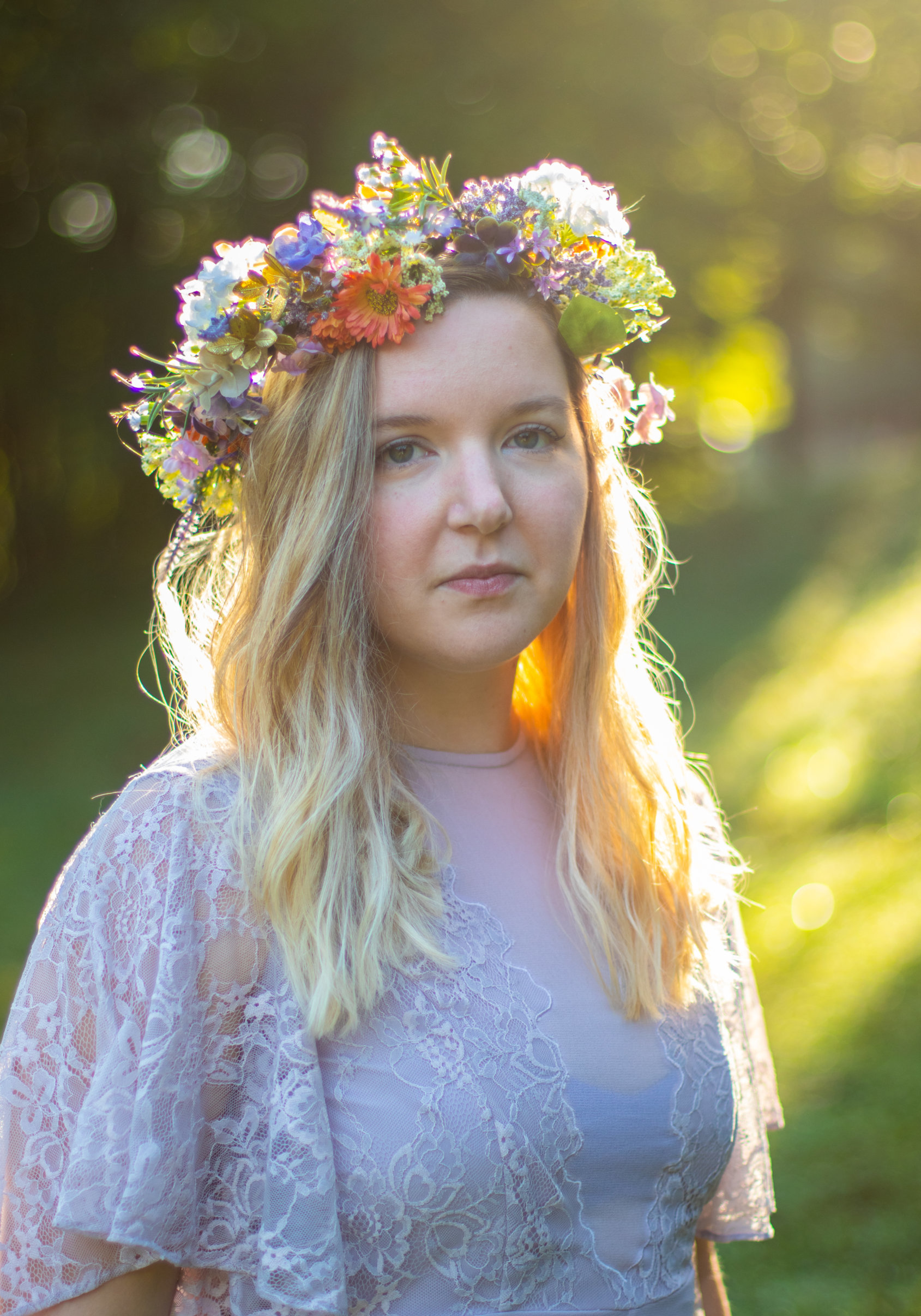 Girl in a purple dress with a flower crown illuminated by golden sun at Kilgore Falls photo shoot